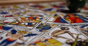 Tirage de tarot intuitif lors de l’atelier au Manoir de Kerledan, 22-23 mars 2025. Cartes étalées sur une table en bois, ambiance feutrée et bougies allumées.