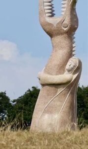 Statues monumentales en granit de la Vallée des Saints à Carnoët, sous un ciel breton.